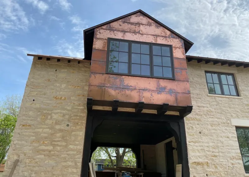 Copper metal panel facade on a stone building for Roof Repair in Evans